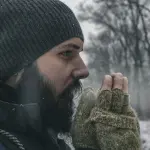 homme barbu en hiver avec bonnet et gants dans la neige