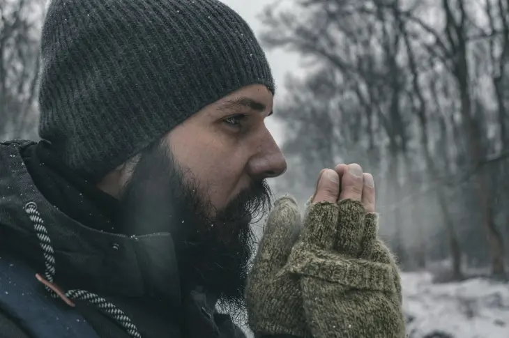 homme barbu en hiver avec bonnet et gants dans la neige