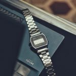 a watch sitting on top of a book on a table