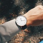 person wearing round silver-colored analog watch at 1:19
