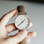 person holding analog watch